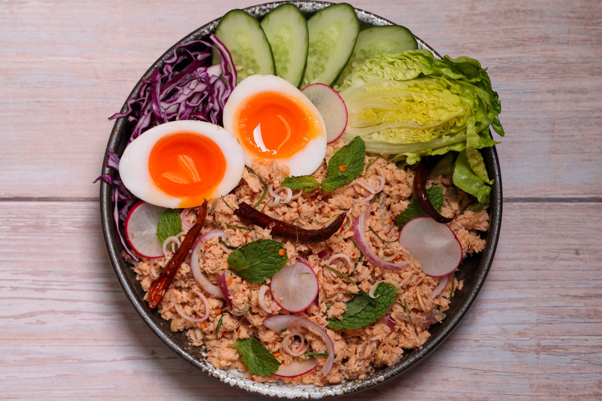 Salmon larb with roasted coconut & herbs, onsen eggs & crisp vegetables